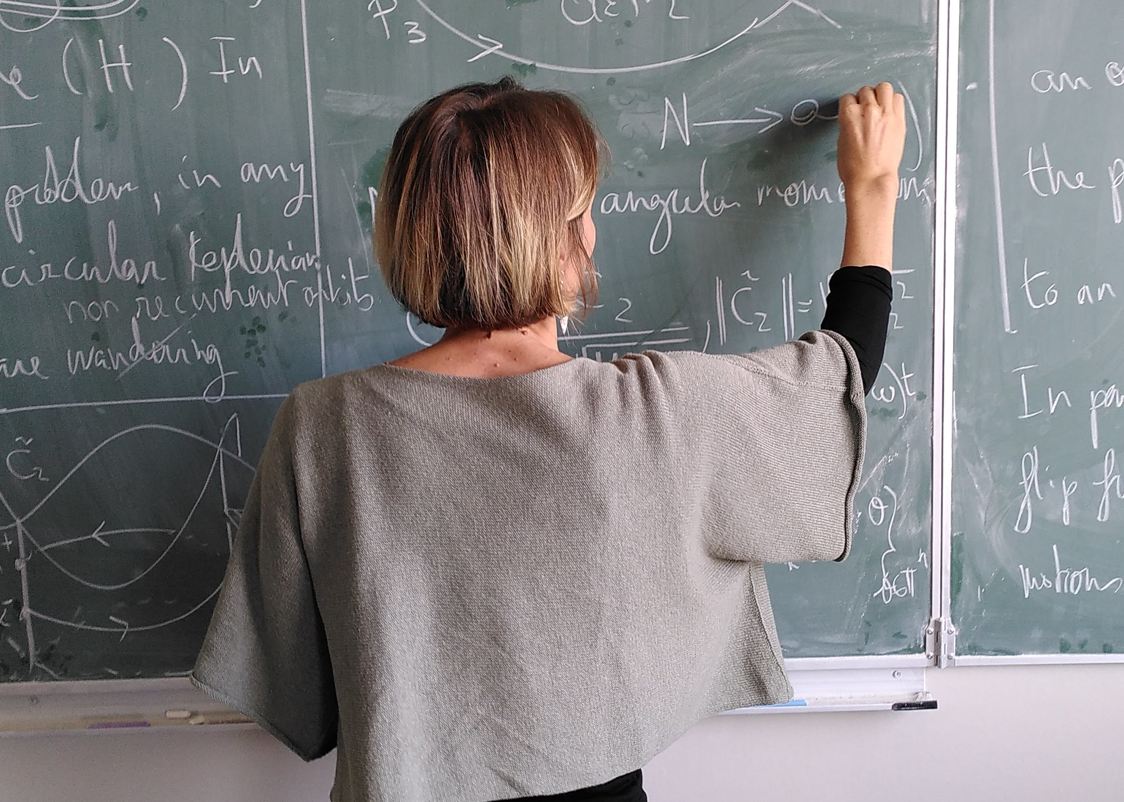 A mathematician writing on a blackboard